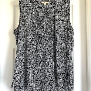 Super versatile sleeveless blouse with mini pleats and hidden button placket.